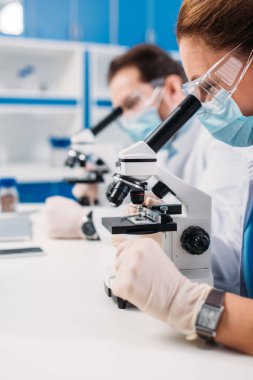 seçici odak tıbbi bilim adamları maskeleri ve mikroskoplar vekiller laboratuarında üzerinde üzerinden seyir koruyucu gözlük