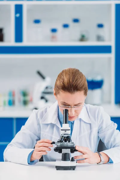 Científica Femenina Anteojos Que Mira Reactivo Través Del Microscopio Laboratorio — Foto de Stock