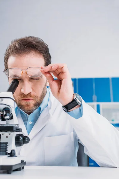 Wissenschaftler Weißem Kittel Und Brille Blickt Durch Das Mikroskop Auf — Stockfoto