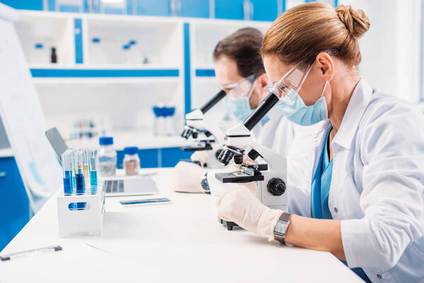 Enfoque Selectivo Los Científicos Máscaras Médicas Gafas Mirando Través Microscopios — Foto de Stock