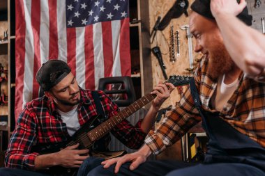 yakışıklı mekaniği garajda gitar çalmak