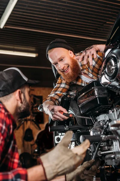 Mecánicos Guapos Hablando Mientras Reparan Motocicleta Juntos Garaje — Foto de Stock