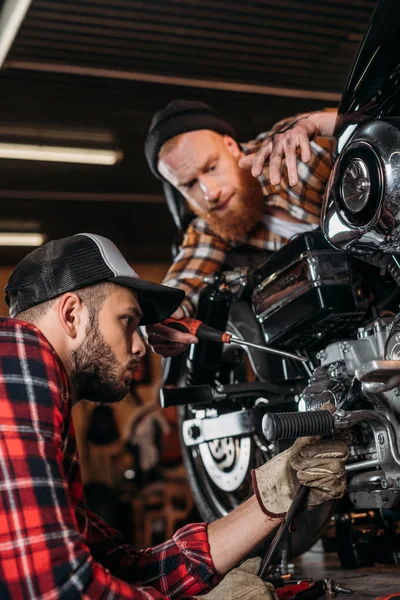 ハンサムな若いメカニック ガレージでバイクを一緒に修復 — ストック写真