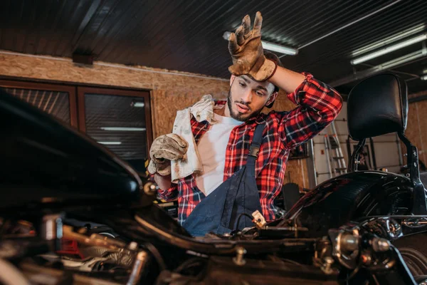 Exhausted Bike Repair Station Worker Wiping Sweat Forehead Work Garage — Stock Photo, Image