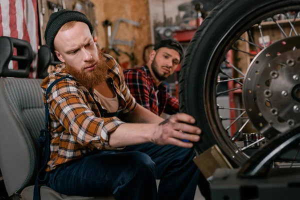 Handsome Mechanics Examining Wheel Motorcycle Garage — Stock Photo, Image