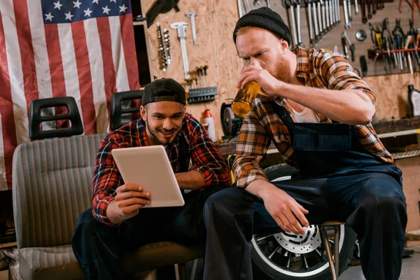 Jóvenes Mecánicos Beber Cerveza Uso Tabletas Juntos Garaje — Foto de stock gratis