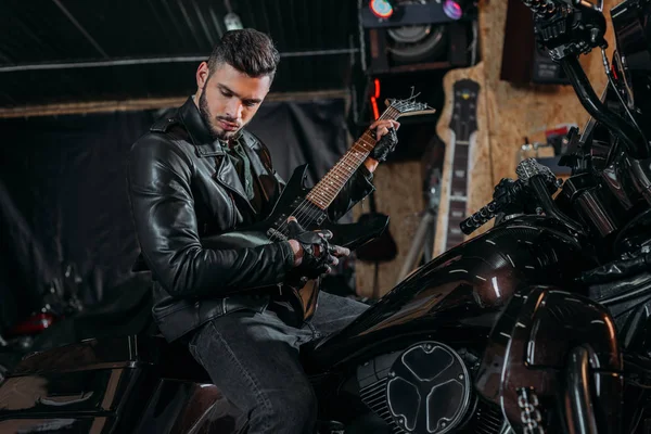 Joven Guapo Tocando Guitarra Mientras Está Sentado Bicicleta Garaje — Foto de Stock