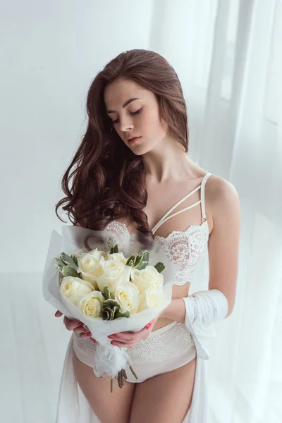 ウィンドウに立って手でバラの花束と一緒に下着姿で物思いにふける女 — ストック写真