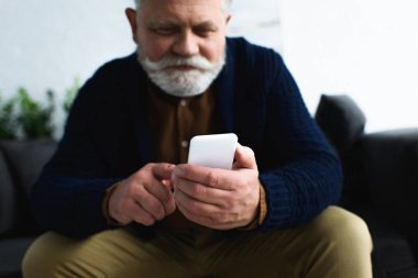 akıllı telefon kullanarak gülümseyen kıdemli adam