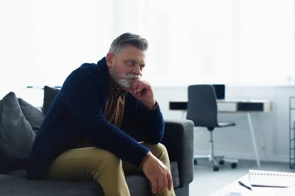 Pensive Bearded Man Sitting Sofa Looking Away Home — Stock Photo, Image