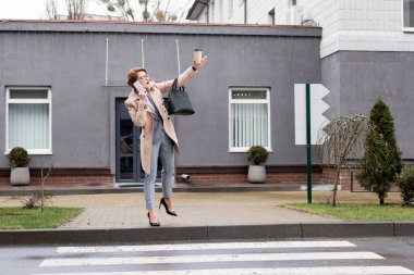 işkadını kahve ile smartphone üzerinde konuşmak ve sokakta taksi arıyorum