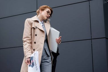 işkadını smartphone Caddesi üzerinde konuşurken belgelerle