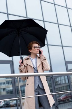işkadını smartphone Caddesi üzerinde konuşurken şemsiye ile