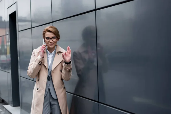 Üzletasszony Mutatja Jele Miközben Beszélt Smartphone Utcában — ingyenes stock fotók
