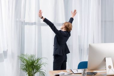işkadını germe ve ofis pencere bakarak elbiseli yan görünüm