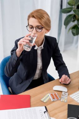 takım elbise içme suyu işyerinde iş kadını ofiste haplarla