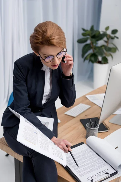 Kadını Ofiste Işyerinde Smartphone Cep Telefonu Ile Konuşurken Sözleşme Arıyor — Ücretsiz Stok Fotoğraf