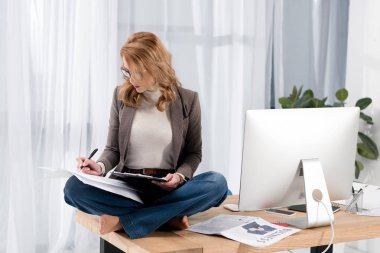 iş kadını ofiste tabloda otururken evrak işi gözlük