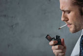Nahaufnahme Porträt eines Mannes, der vor einer Betonwand Zigarette raucht
