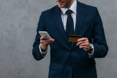 işadamı kredi kartı ve e-alışveriş yapma smartphone ile kadeh kırpılmış