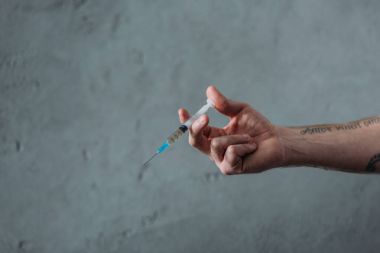 cropped shot of junkie holding heroin syringe clipart