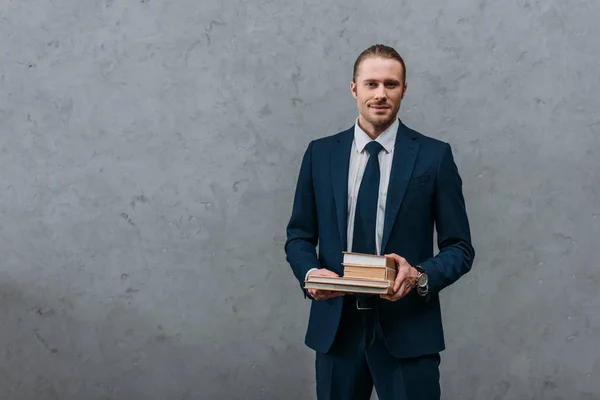 Young Handsome Businessman Holding Stack Books Front Concrete Wall — Stock Photo, Image