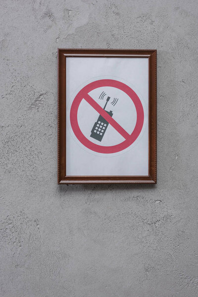 restricted phone placard on concrete wall