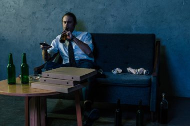 tv izlerken, işten sonra bira içmeye Beyaz tişörtlü adam depresif alkol bağımlısı