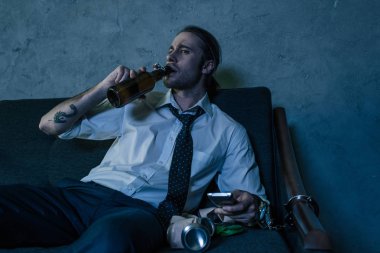 tv izlerken, işten sonra bira içmeye Beyaz tişörtlü adam genç alkol bağımlısı
