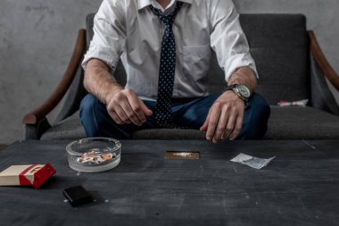 cropped shot of businessman with drug addiction preparing to take cocaine clipart