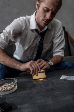 businessman with drug addiction preparing to take cocaine clipart