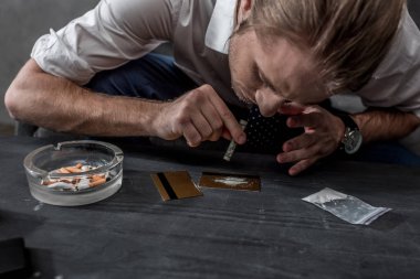close-up shot of businessman with drug addiction sniffing cocaine clipart