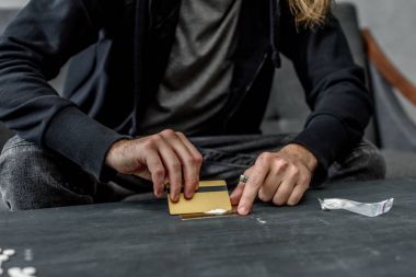 cropped shot of addicted man preparing to take cocaine clipart