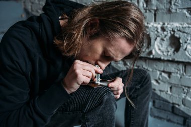 close-up shot of addicted man sniffing cocaine from credit card clipart