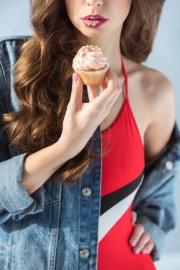 seksi kızı kırmızı mayo gri izole cupcake tutarak kırpılmış görüntü