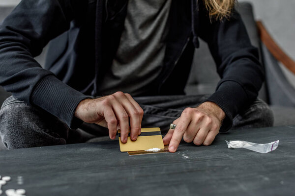 cropped shot of addicted man preparing to take cocaine