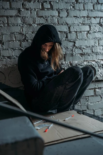 Hooded Heroïne Verslaafd Junkie Zittend Trap Met Spuiten — Gratis stockfoto