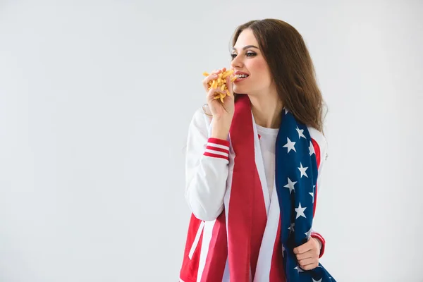 性感微笑的女孩与美国国旗吃法国薯条孤立的白色 — 图库照片