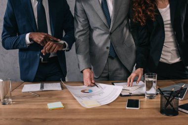 Cropped image of three business colleagues doing paperwork clipart