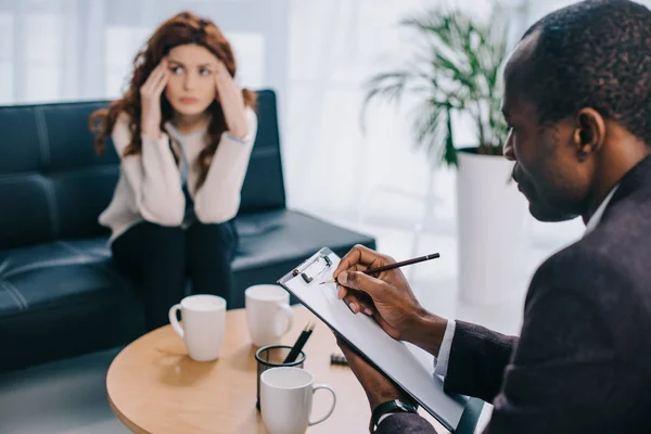 Upset Woman Sitting Sofa Psychiatrist Writing Clipboard — Stock Photo, Image