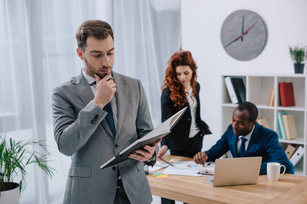 Multiethnic business colleagues doing paperwork in office