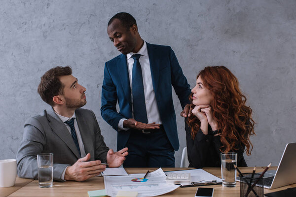 Финансовый консультант беседует с деловыми партнерами за столом
