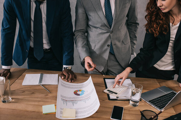 Обрезанный взгляд на бизнес-коллег, делающих бумажную работу
 