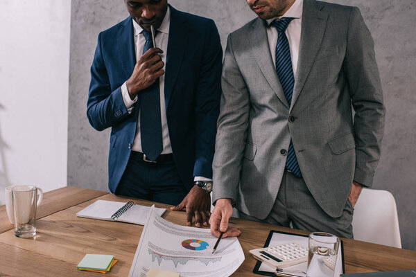 Cropped view of two stylish businessmen doing paperwork 