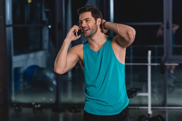 happy sportsman talking on smartphone in gym