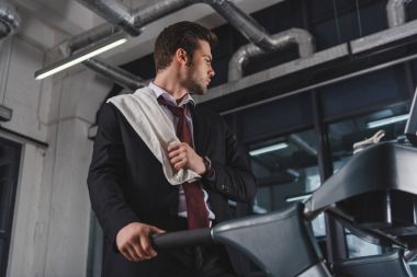 havlu eğitim spor salonunda treadmill ile yorgun işadamı 