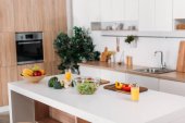 Interiér moderní kuchyně s zeleninu, ovoce a salát na stole 