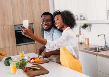 Genç çift selfie kesme sebze gemide iken masada alarak gülümseyen