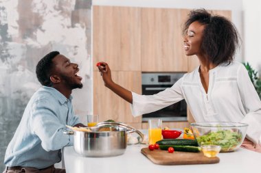 Kiraz domates erkek arkadaşına bir gülümseyen kadın yan görünüm 