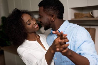 Smiling african american couple holding each other hands clipart